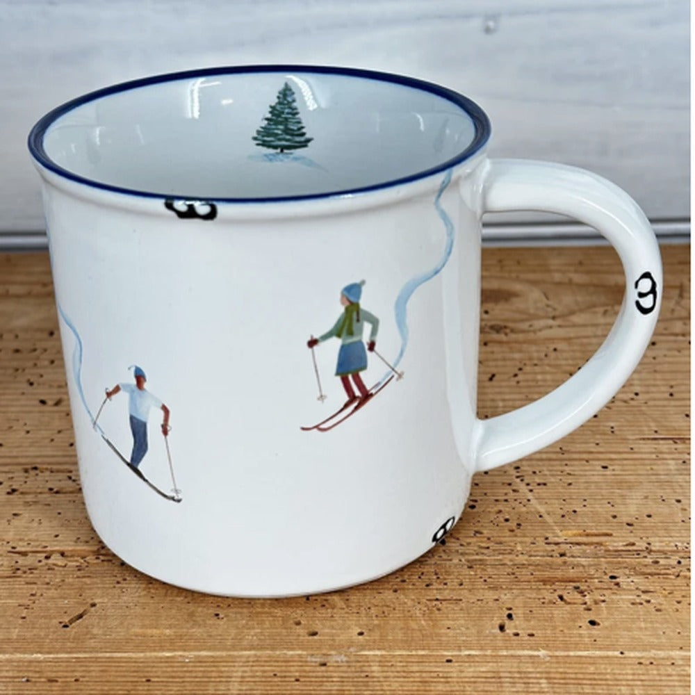 Tasse Skipaar: weiße Emaille-Tasse mit Skifahrer und Skifahrerin und Tannenbaum im Inneren